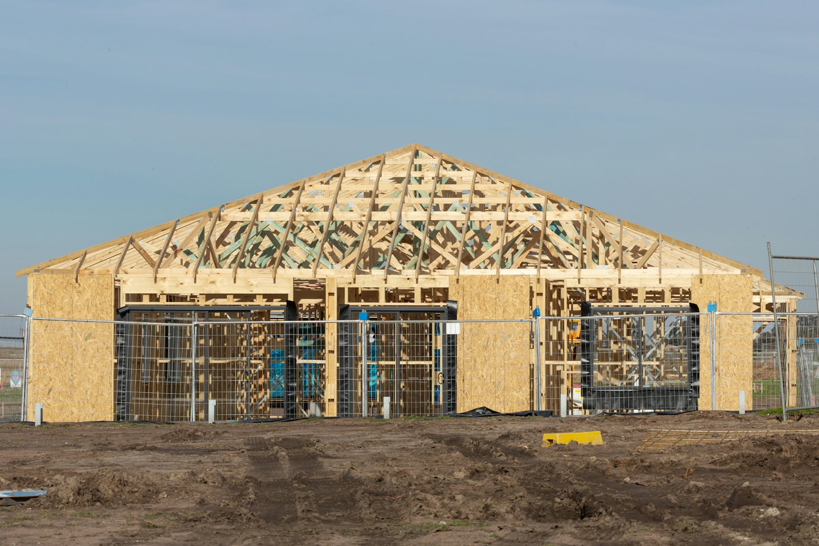 A timber-framed house under construction, with the roof structure exposed